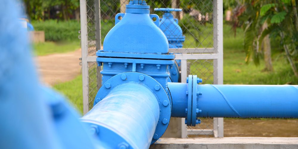 A closeup of blue sewage pipes above ground