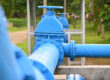 A closeup of blue sewage pipes above ground