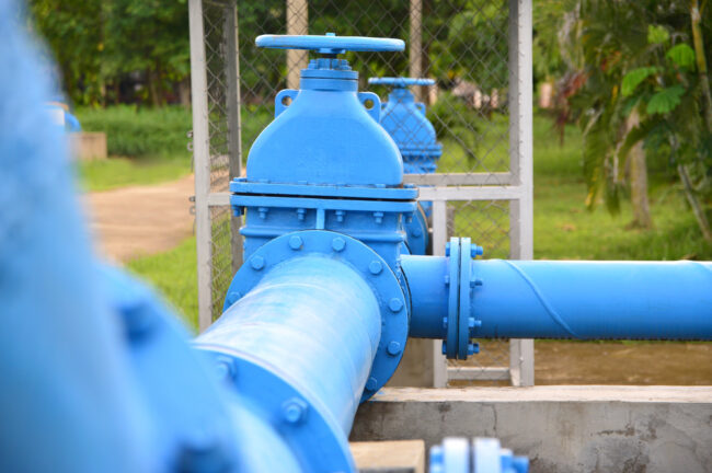 A closeup of blue sewage pipes above ground