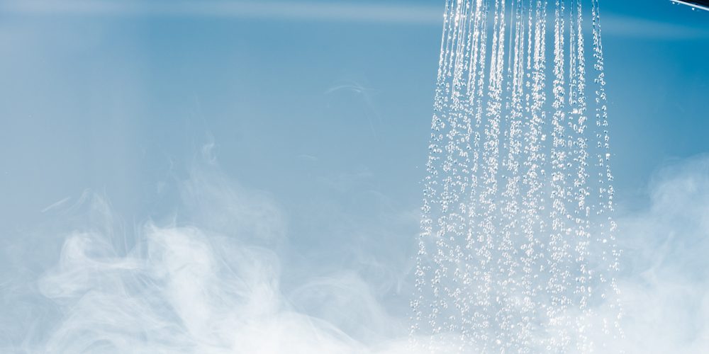 A shower head with running water and steam