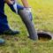 A worker uses a big pipe to clear out a household septic system